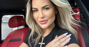 influenciadora Deolane Bezerra de cabelo solto e roupa preta, posando dentro de carro, séria