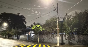 Rua à noite, com chuva e escola