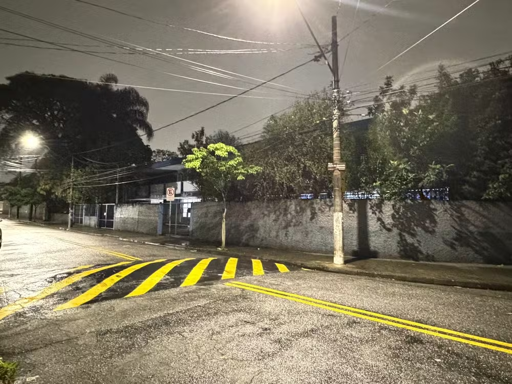 Rua à noite, com chuva e escola