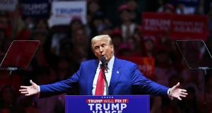 Donald Trump no Madison Square Garden, em Nova York, falando, com os braços abertos
