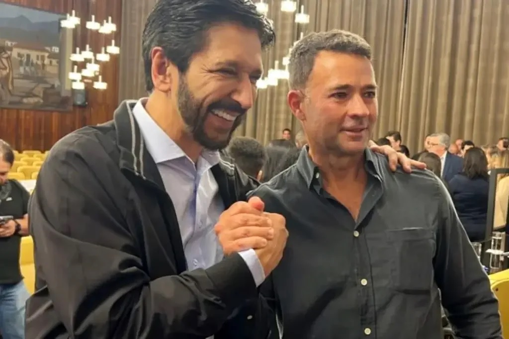 Ricardo Nunes sorrindo em aperto de mãos com Mello Araujo