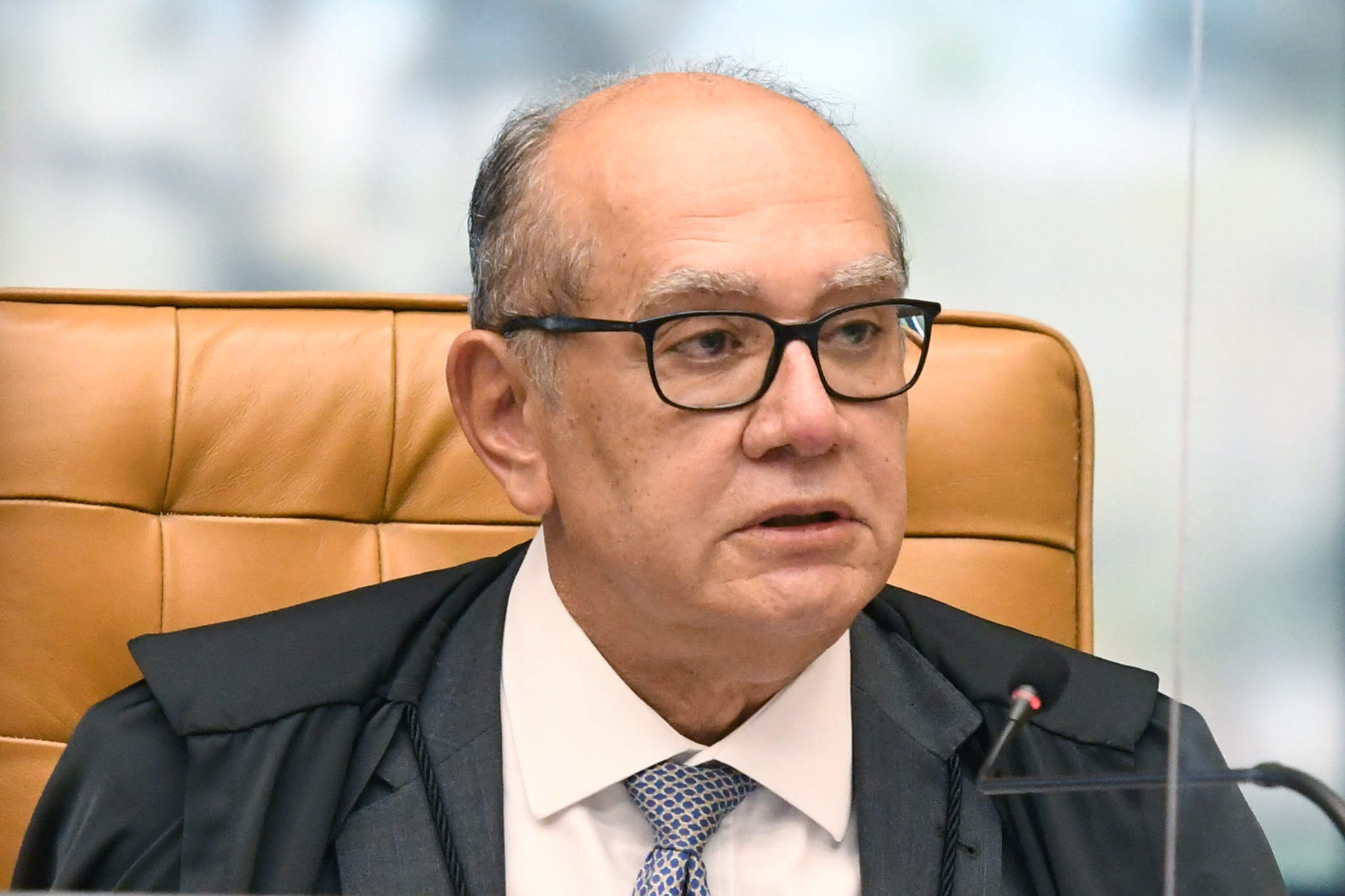 Ministro Gilmar Mendes, do Supremo Tribunal Federal (STF), com expressão observadora, olhando para o lado, de óculos