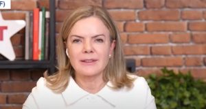 Gleisi Hoffmann, presidente nacional do PT, de roupa branca e cabelo solto, falando para a câmera