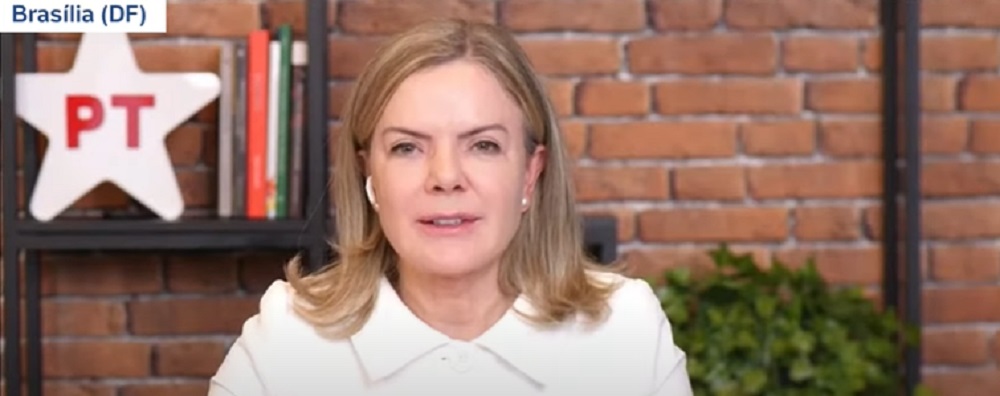 Gleisi Hoffmann, presidente nacional do PT, de roupa branca e cabelo solto, falando para a câmera