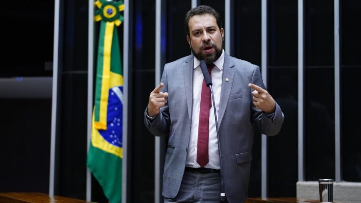 O candidato Guilherme Boulos (PSOL) na Câmara dos Deputados, falando e gesticulando com expressão séria