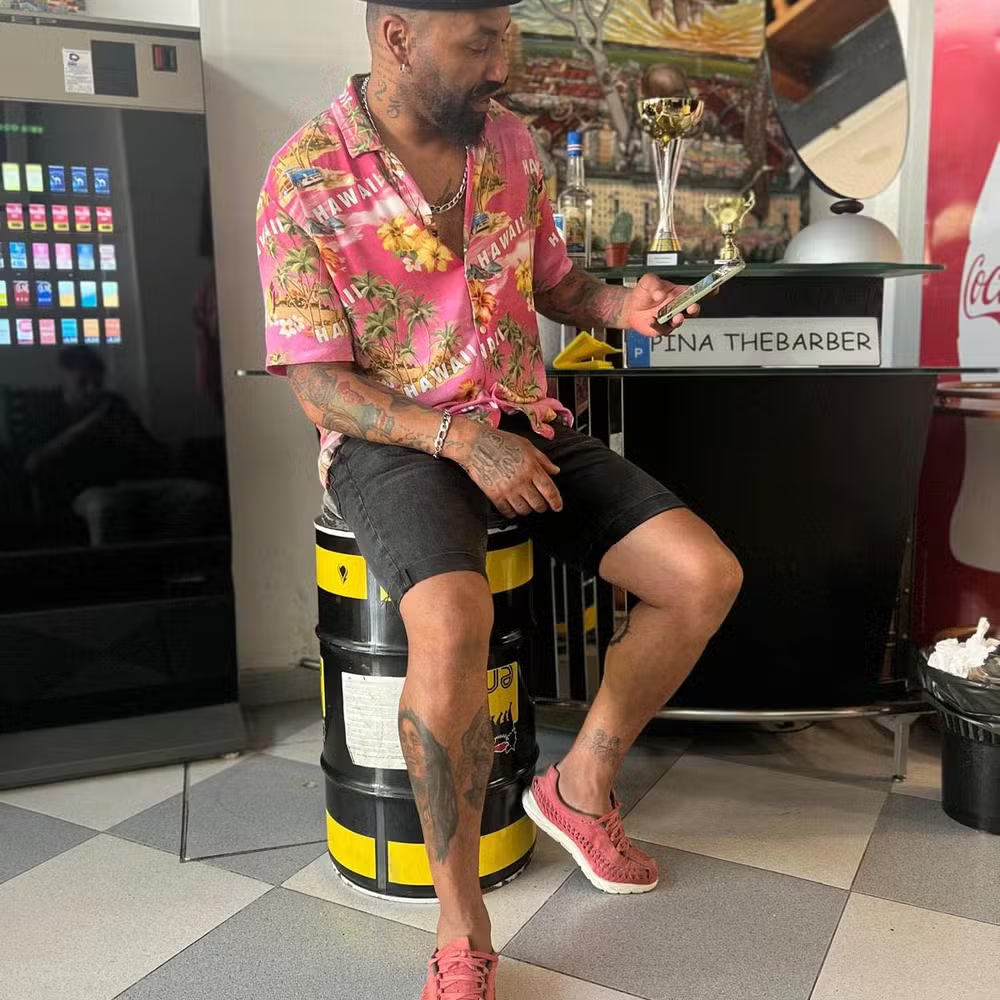 Carlos Pina sentado em barbearia, sem olhar para foto