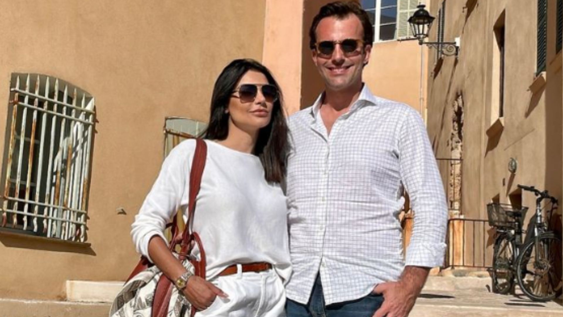 A influenciadora Cíntia Chagas e o deputado estadual Lucas Bove (PL-SP) posando de roupas claras e óculos escuros, só ele sorrindo