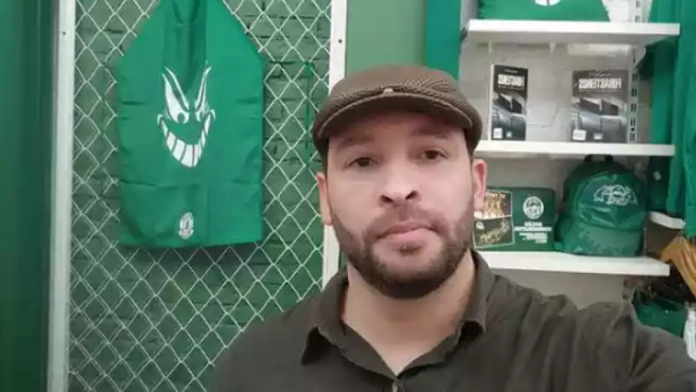 Jorge Luis Sampaio, presidente da torcida organizada Mancha Verde, sério, de roupa e boina marrons