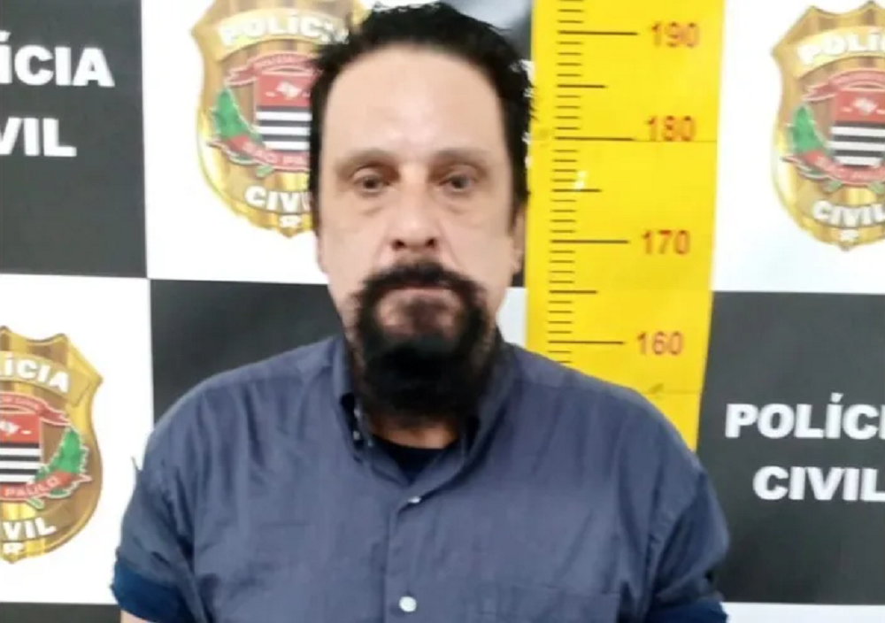 Paulo Cupertino, acusado de assassinar o ator Rafael Miguel e seus pais, sério, posando na delegacia