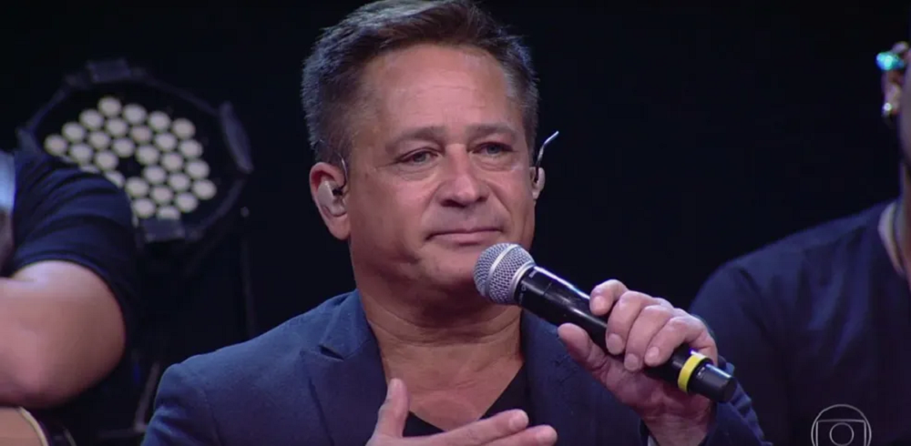 O cantor Leonardo de roupa escura, sério, segurando microfone