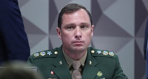Mauro Cid fardado, com expressão séria, olhando pra frente