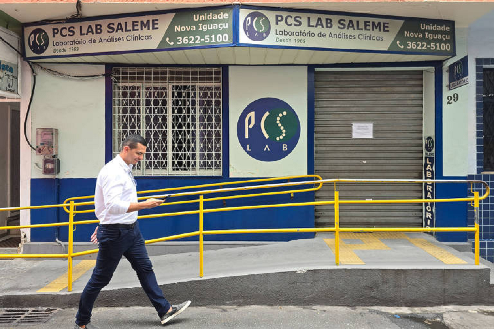 Homem passando em frente ao Laboratório PCS Saleme, em Nova Iguaçu