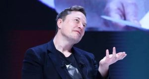 Elon Musk falando e gesticulando com expressão pensativa