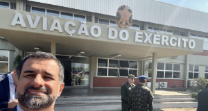 coronel da reserva Anderson Freire Barboza fazendo selfie sorrindo perto de espaço de aviação do Exército