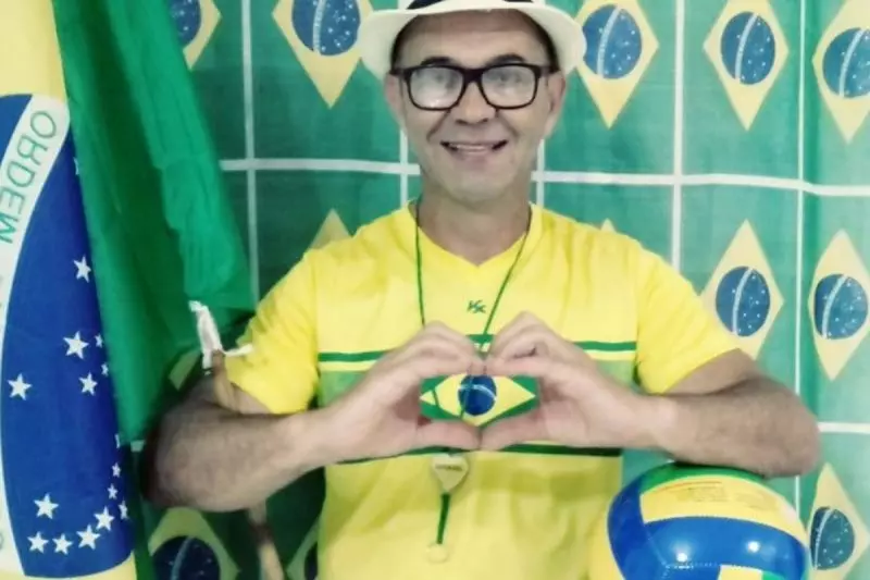 Francisco Wanderley Luiz de roupa do Brasil fazendo coração com as mãos