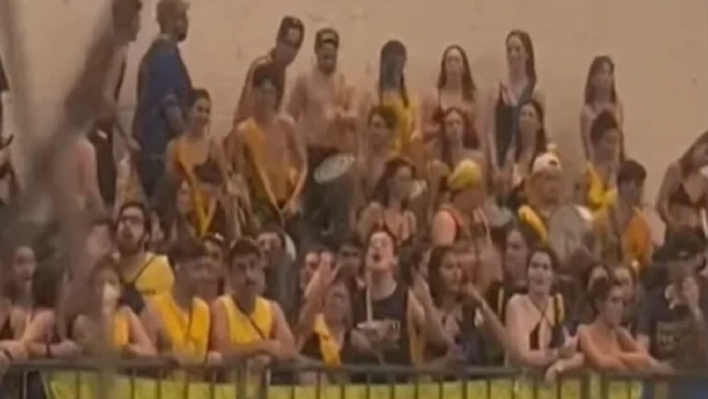 Estudantes gritando, de uniforme azul e amarelo