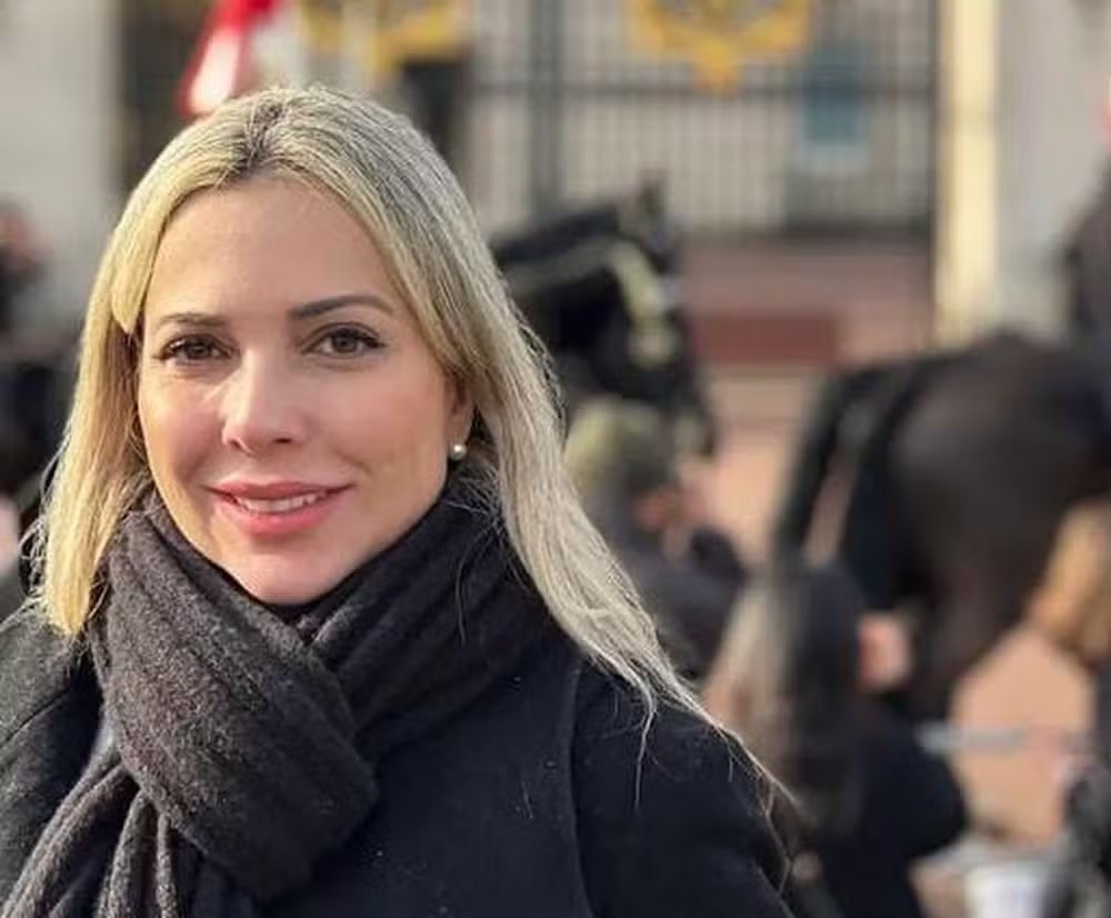 A cirurgiã plástica Daniele Barreto de roupa de frio e cabelo solto, sorrindo para foto