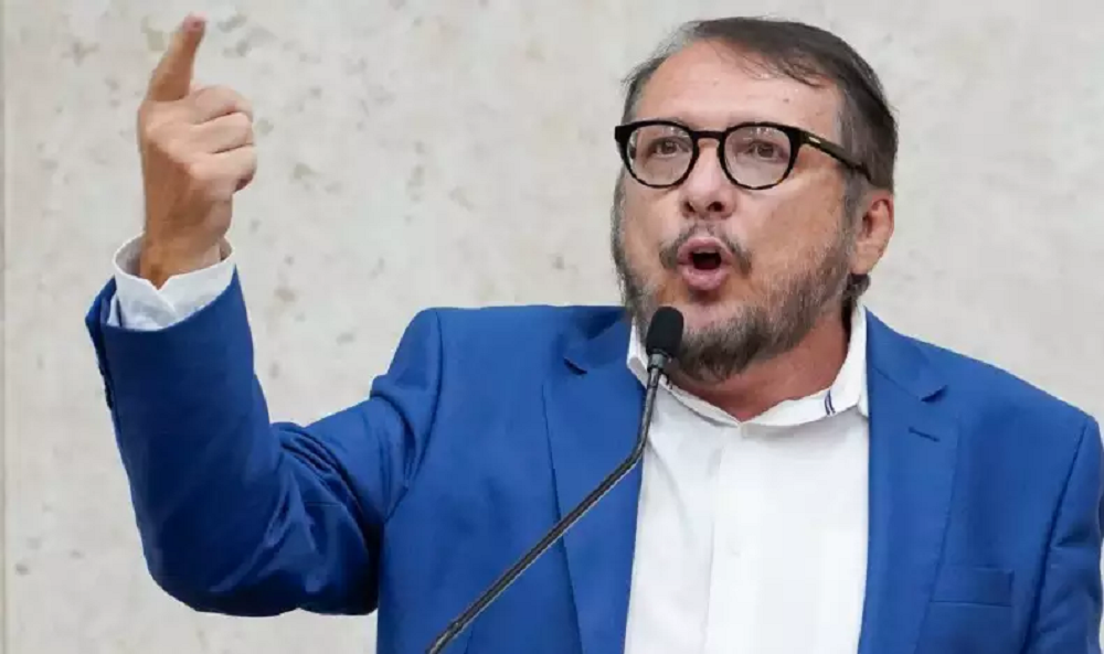 vereador Toninho Vespoli (PSOL) falando em microfone e apontando, sério, de roupa social azul e branca
