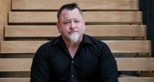 Luis Elizondo, ex-oficial de Defesa dos Estados Unidos, de camisa social preta, olhando sério para frente
