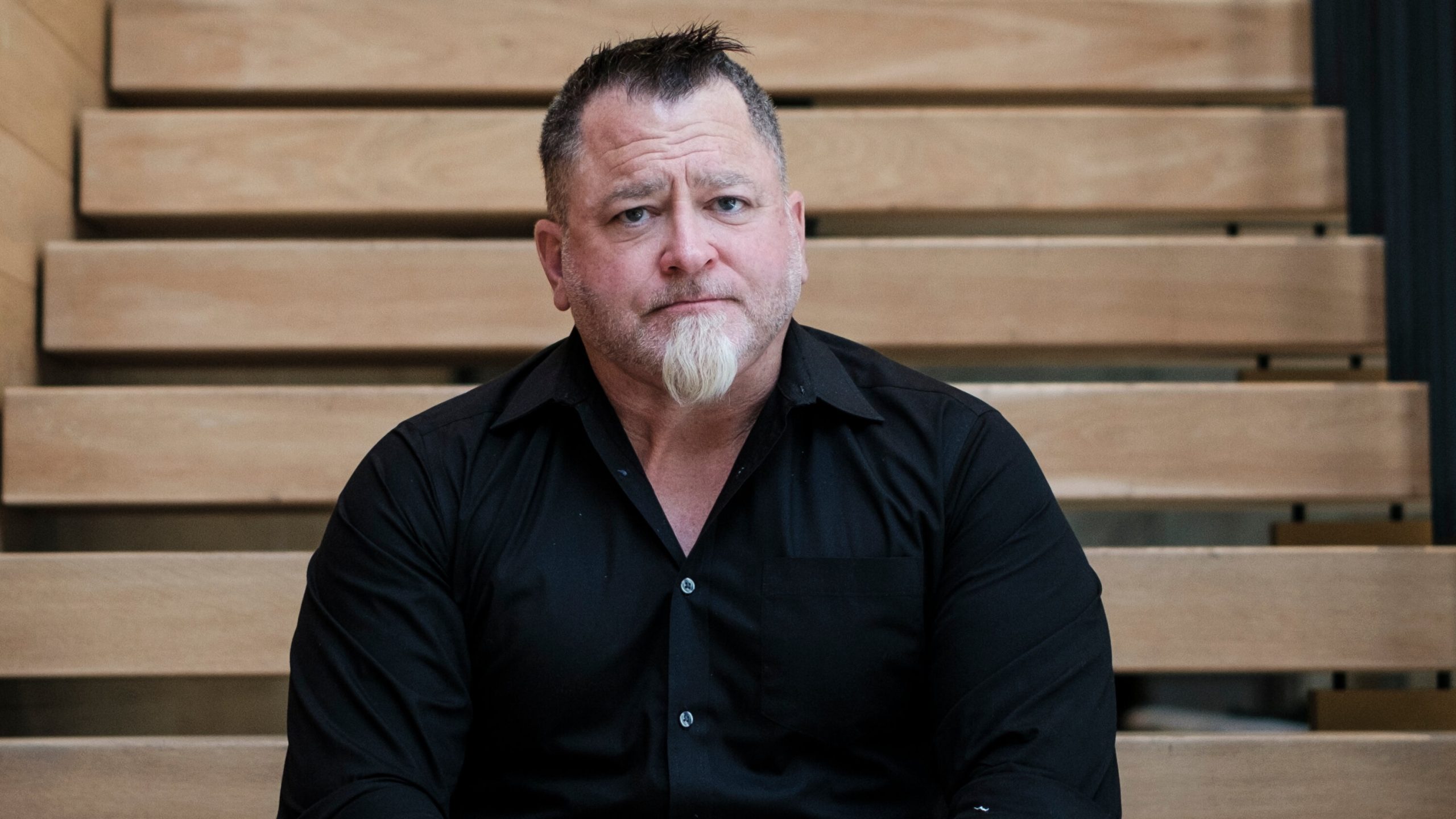 Luis Elizondo, ex-oficial de Defesa dos Estados Unidos, de camisa social preta, olhando sério para frente