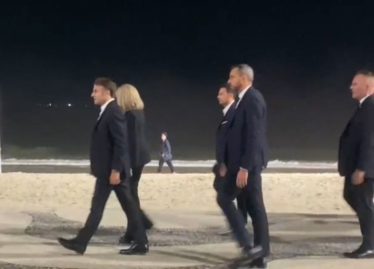 O presidente da França, Emmanuel Macron, e sua esposa, Brigitte Macron, caminhando em Copacabana com seguranças