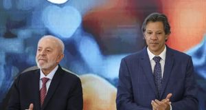 Lula e Fernando Haddad lado a lado, sérios, aplaudindo