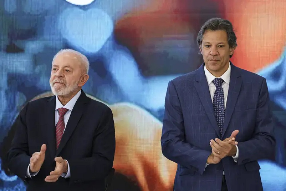 Lula e Fernando Haddad lado a lado, sérios, aplaudindo