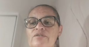 A professora Sueli Santana de óculos e cabelo preso, falando, sem olhar para a câmera, em close