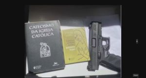 Foto de arma de fogo e livros religiosos