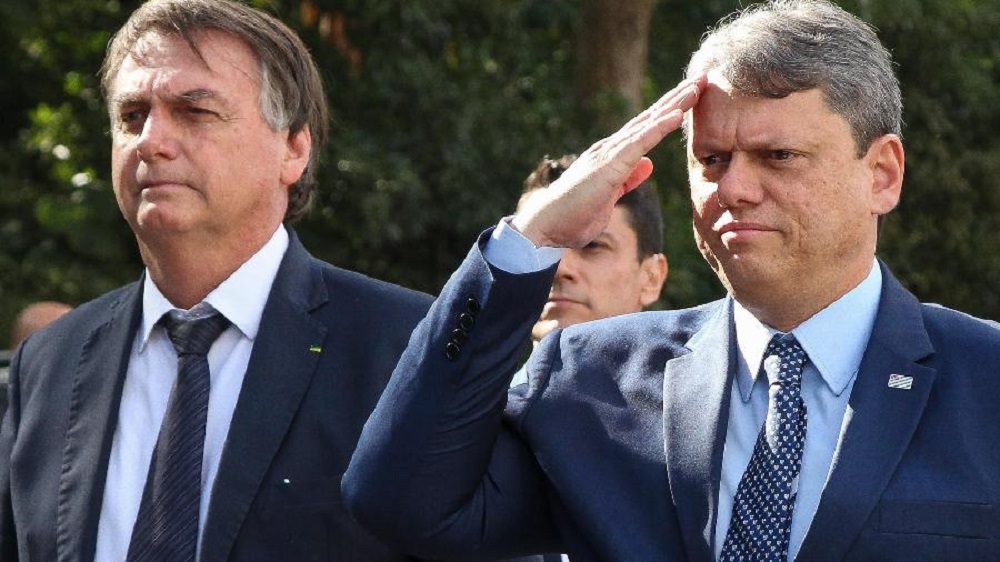 O ex-presidente Jair Bolsonaro (PL) e o governador de São Paulo Tarcísio de Freitas (Republicanos), o segundo batendo continência e o primeiro sério