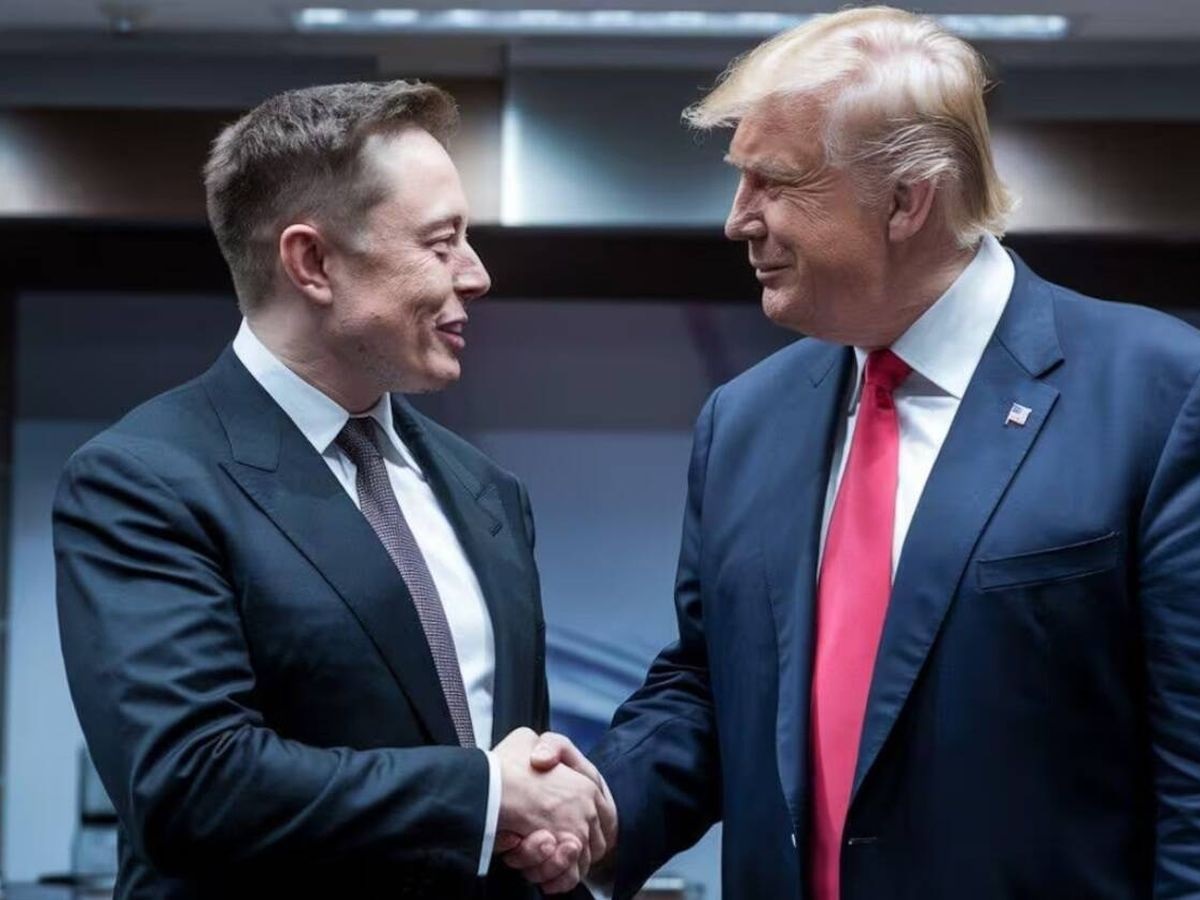 Elon Musk e Donald Trump sorrindo e se olhando, em aperto de mãos