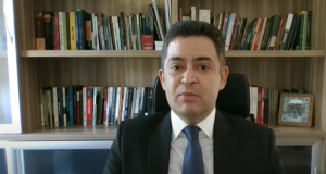 juiz federal Sandro Nunes Vieira falando para a câmera com livros atrás
