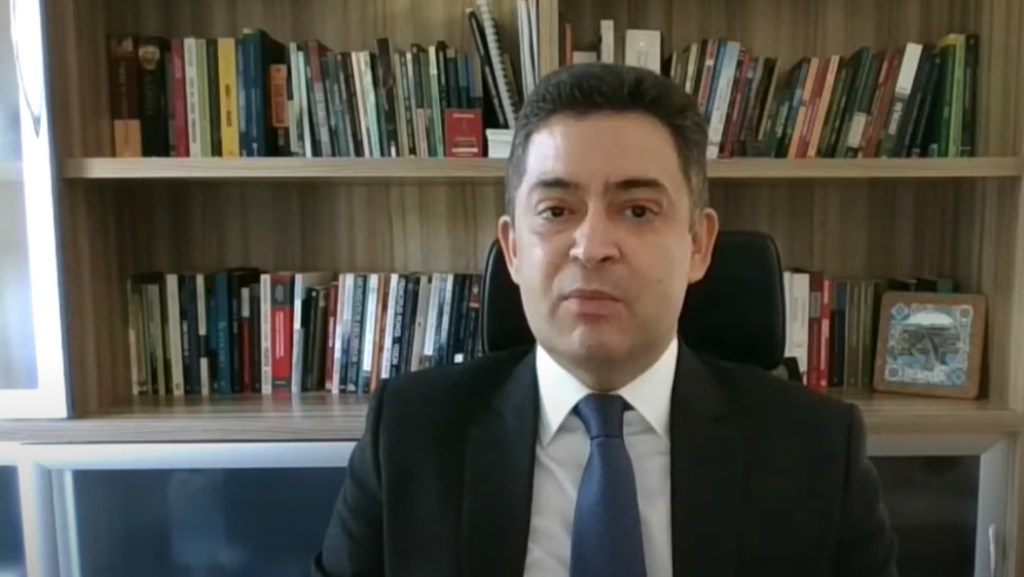juiz federal Sandro Nunes Vieira falando para a câmera com livros atrás