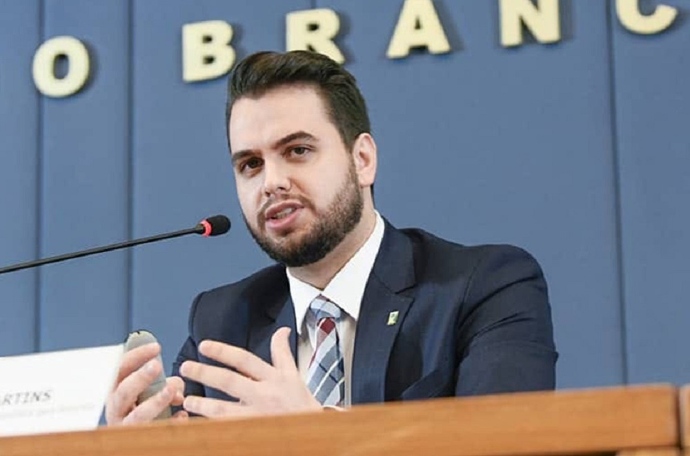 Filipe Garcia Martins, ex-assessor especial da Presidência, falando em microfone e gesticulando, sentado, sério