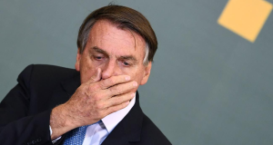 Jair Bolsonaro (PL) com mão na boca e expressão de surpresa