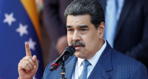Nicolás Maduro falando em microfone, sério, apontando pra cima