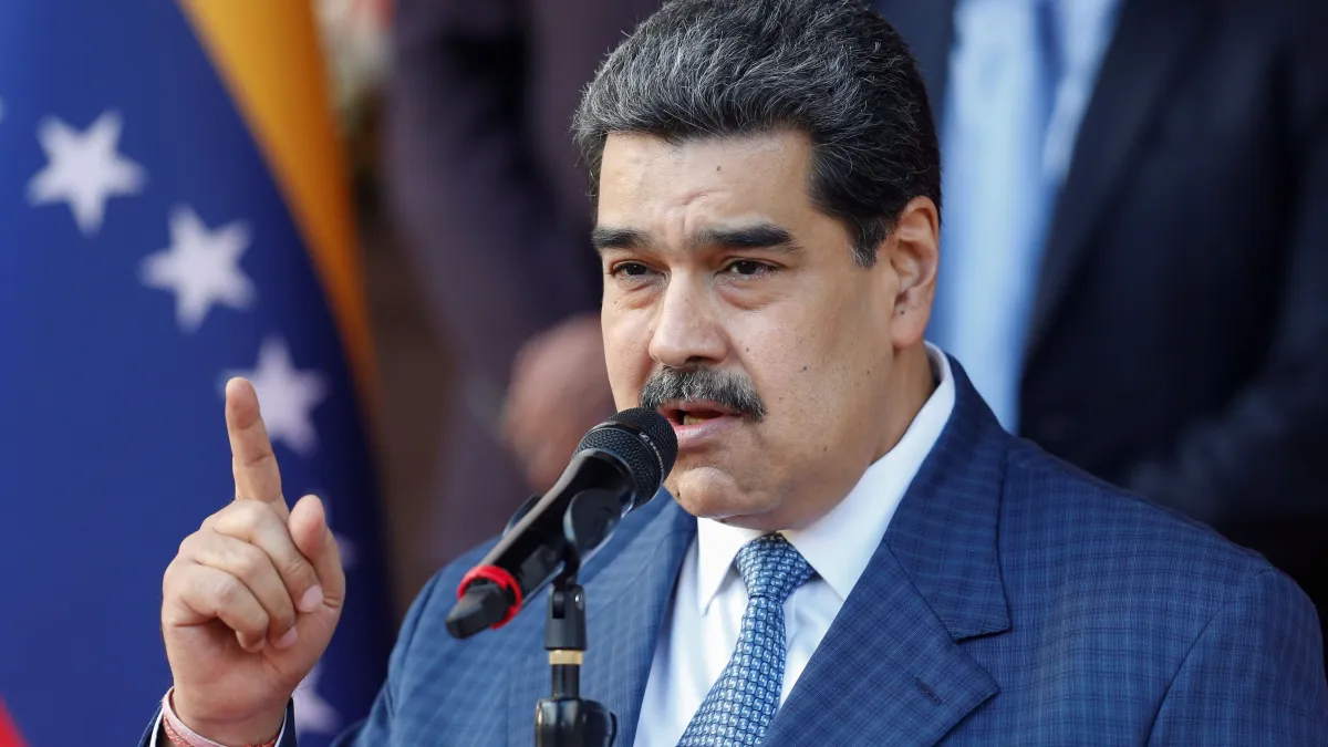 Nicolás Maduro falando em microfone, sério, apontando pra cima