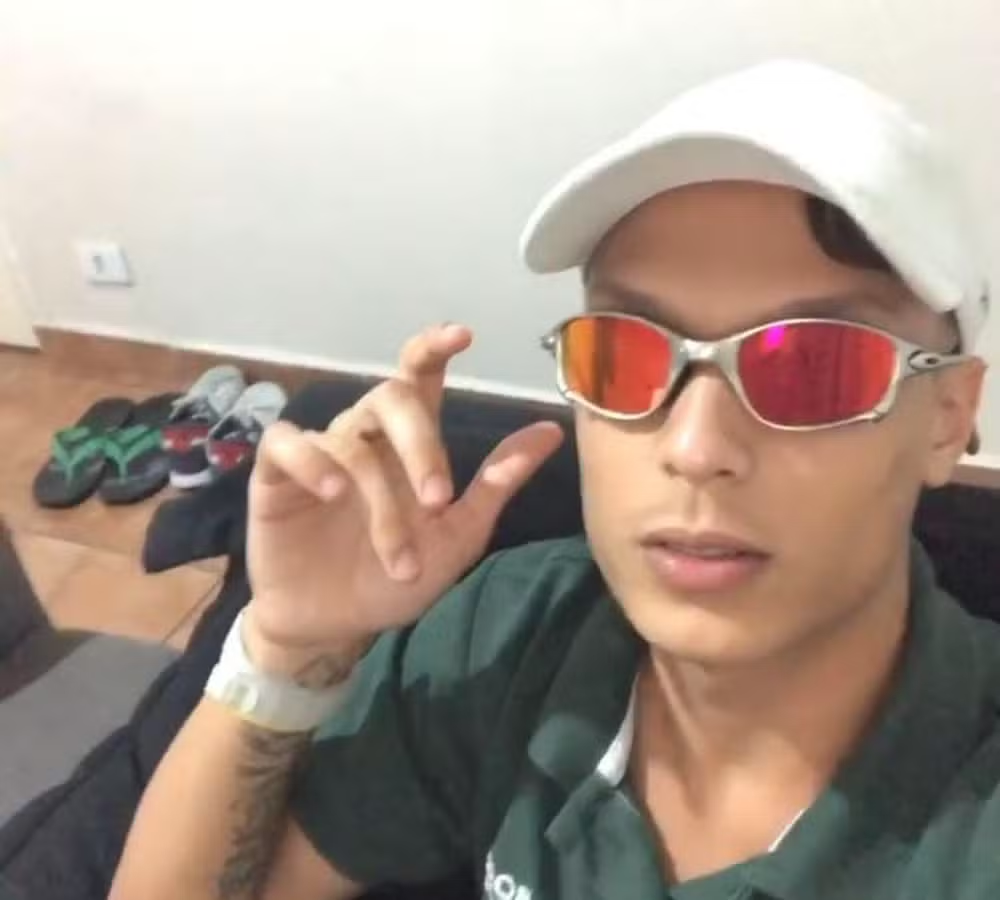 Jonatas Almeida dos Anjos, de 18 anos, de óculos escuros e boné posando para foto