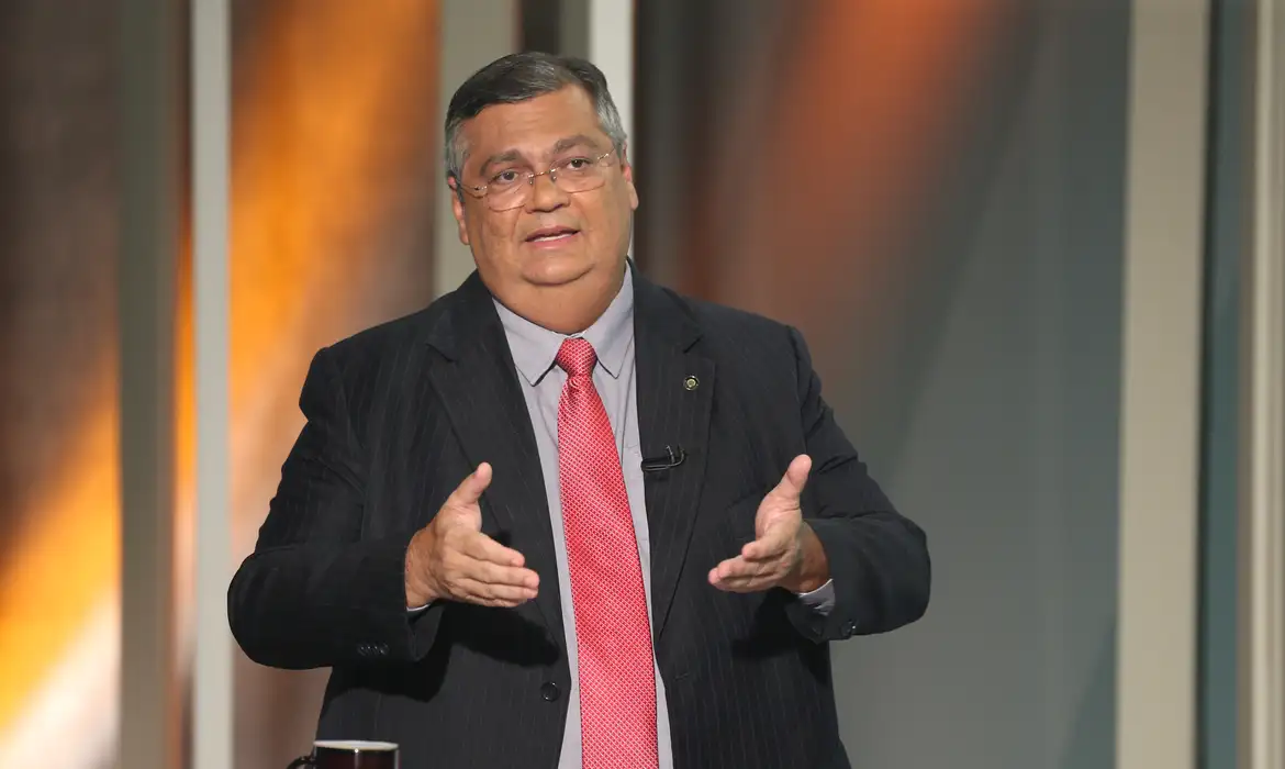 ministro do Supremo Tribunal Federal (STF), Flávio Dino falando e gesticulando, de óculos e roupa social, sério