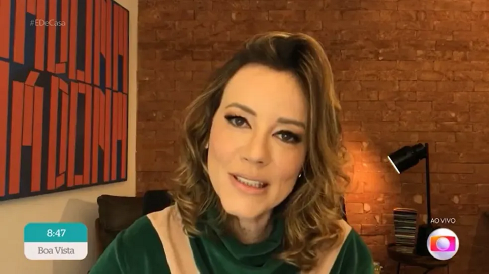 jornalista Natuza Nery falando para a câmera, de cabelo solto e roupa verde