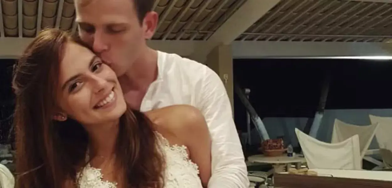O estudante Fernando Ressurreição e a médica Carolina Canales abraçados, ele beijando o rosto dela, ela sorrindo