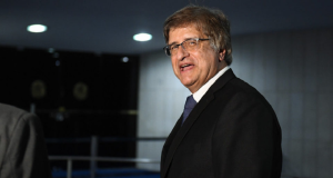O procurador-geral da República, Paulo Gonet, falando e olhando para a câmera, de óculos, em pé