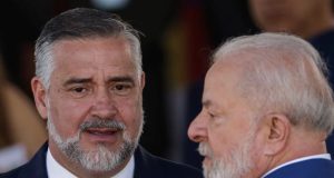 O ministro Paulo Pimenta e o presidente Lula conversando, sérios, em close