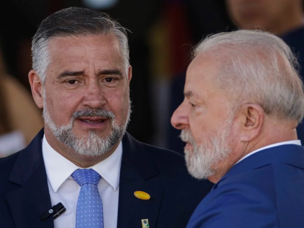 O ministro Paulo Pimenta e o presidente Lula conversando, sérios, em close