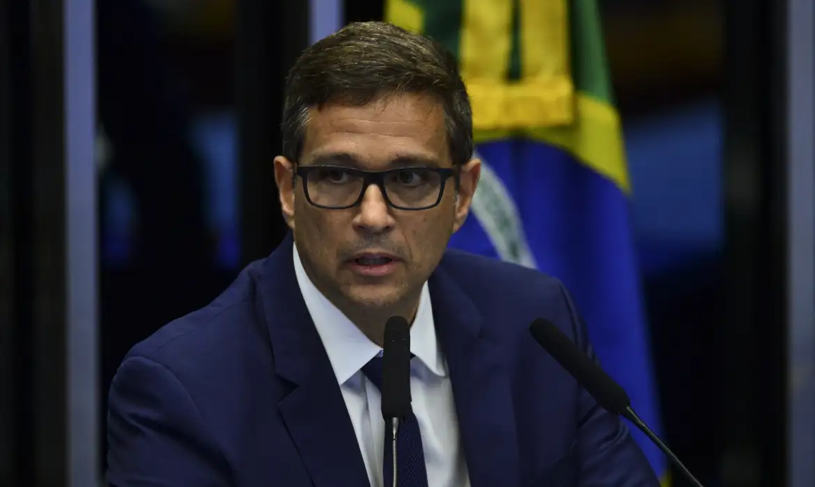 presidente do Banco Central, Roberto Campos Neto, sério, falando em microfone