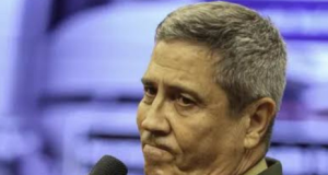 general Braga Netto fardado, segurando microfone, com expressão de tristeza