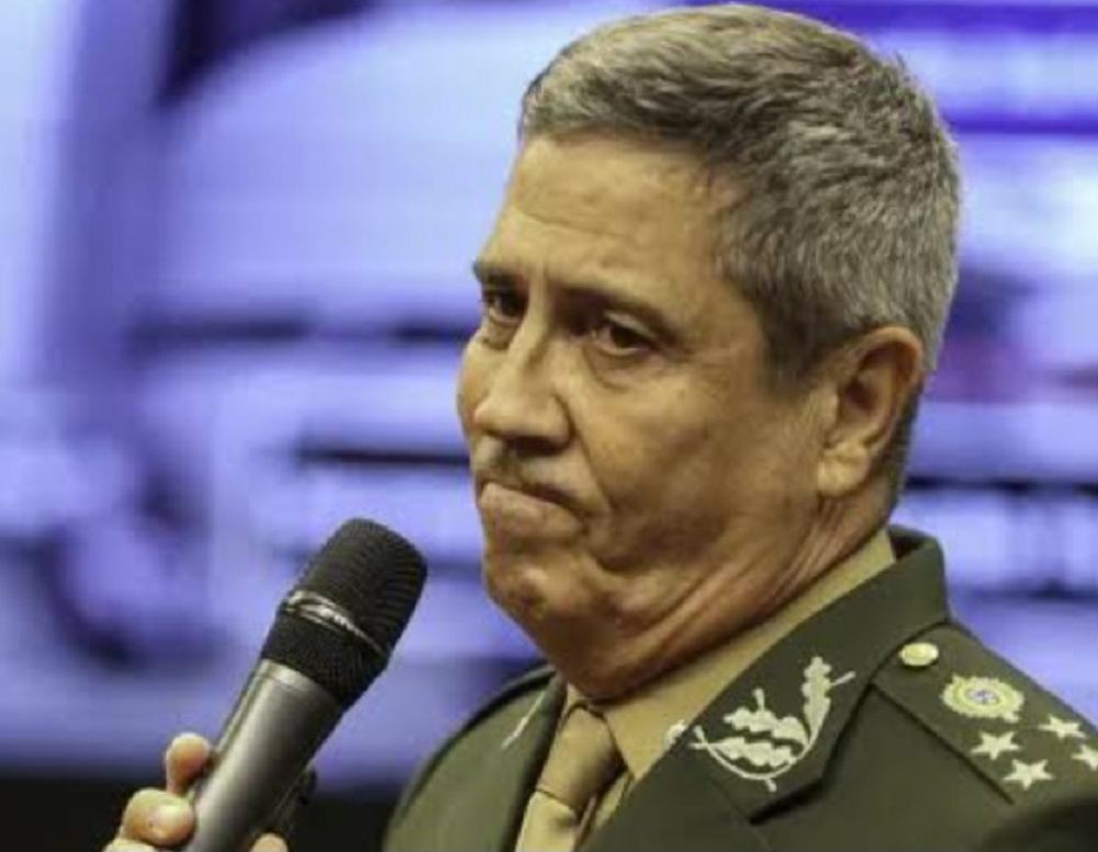 general Braga Netto fardado, segurando microfone, com expressão de tristeza