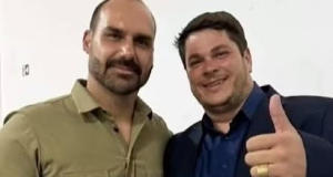 O deputado federal Eduardo Bolsonaro (PL) junto a Osvaldo Cabal, ambos sorrindo lado a lado, o segundo fazendo sinal de joia