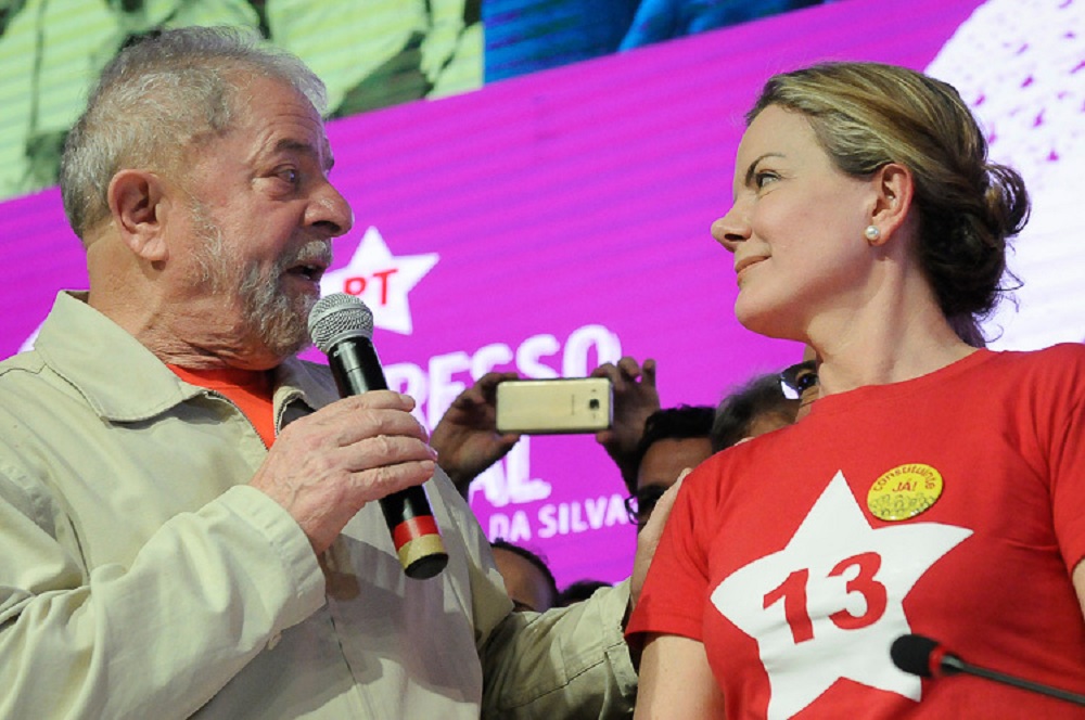 Lula e Gleisi se olhando, ele falando em microfone