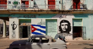 Rua de Cuba com carro antigo estacionado e paredes pintadas